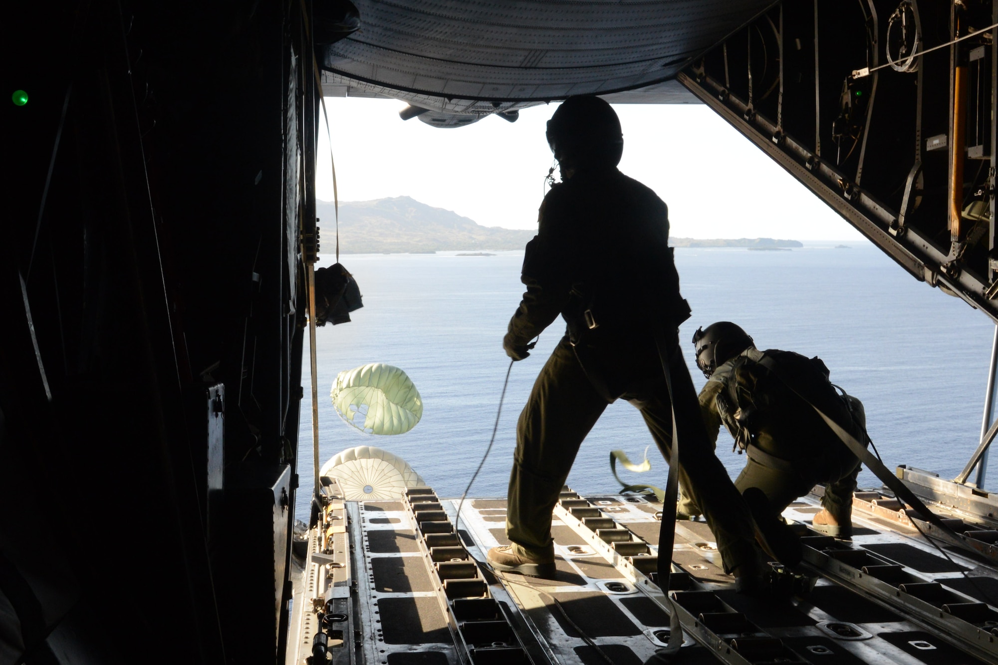 Airman 1st Class Andrew Fox and Staff Sgt. Ralph Oliver, both 36th Airlift Squadron loadmasters from Yokota Air Base, Japan, push airdrop bundle from a C-130 Hercules during humanitarian assistance and disaster relief training Feb. 20, 2014 near Naval Base Guam, as part of Exercise Cope North 2014. Cope North is a multilateral aerial and humanitarian assistance and disaster relief exercise, held annually, designed to increase the combat readiness and interoperability of the U.S. Air Force, U.S. Navy, Japan Air Self-Defense Force, Royal Australian Air Force and Republic of Korea Air Forces. (U.S. Air Force photo by Airman 1st Class Emily A. Bradley/Released)