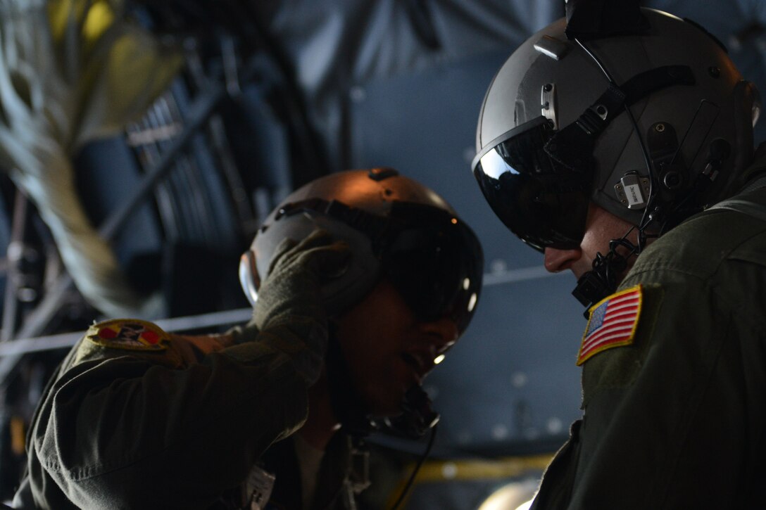 Airman 1st Class Andrew Fox and Staff Sgt. Ralph Oliver, both 36th Airlift Squadron loadmasters from Yokota Air Base, Japan, discuss their plan before pushing an airdrop bundle out of a C-130 Hercules during humanitarian assistance and disaster relief training Feb. 20, 2014, off the coast of Orote Point, Naval Base Guam as part of Exercise Cope North 2014. Cope North is a multilateral aerial and humanitarian assistance and disaster relief exercise, held annually, designed to increase the combat readiness and interoperability of the U.S. Air Force, U.S. Navy, Japan Air Self-Defense Force, Royal Australian Air Force and Republic of Korea Air Forces. (U.S. Air Force photo by Airman 1st Class Emily A. Bradley/Released)