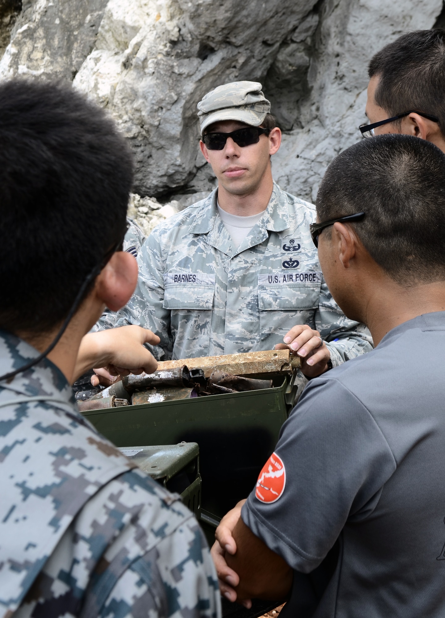 Tech. Sgt. Gabriel Barnes, 36th Civil Engineer Squadron Explosive Ordnance Disposal Flight craftsman, tells Airmen from the Japan Air Self-Defense Force’s 83rd Air Wing about the variety of unexploded ordnances EOD has dealt with during a cultural exchange Feb. 21, 2014, on Andersen Air Force Base, Guam. The JASDF Airmen were here as part of Exercise Cope North 2014, a multilateral training event designed to improve the mission readiness and combined interoperability of the U.S. Air Force, JASDF, and the Royal Australian Air Force. (U.S. Air Force photo by Airman 1st Class Amanda Morris/Released)