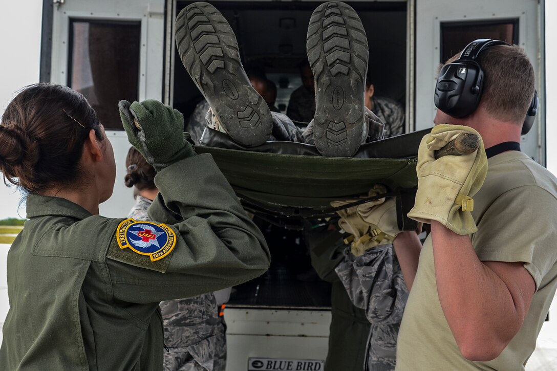 Airmen of the 18th Aeromedical Evacuation Squadron from Kadena Air Base, Japan, and the 36th Medical Group carry a patient into an ambulance Feb. 18, 2014, on Andersen Air Force Base, Guam, during a patient transport exercise. The patient transport was part of a larger combined humanitarian aid and disaster relief exercise during Cope North 2014. (U.S. Air  Force photo by Senior Airman Marianique Santos/Released)