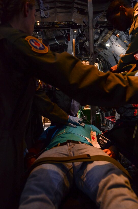 Royal Australian Air Force and U.S. Air Force aeromedical evacuation crewmembers perform resuscitation procedures on a simulated patient during a patient transport exercise in a C-130 Hercules flying over the Pacific Ocean, Feb. 18, 2014 as part of Exercise Cope North 2014. Australian medical crews worked together as one team to move simulated patients from site on Tinian, Commonwealth of the Northern Mariana Islands, onto a C-130 Hercules and provided medical care for the duration of the flight back to Andersen Air Force Base, Guam. (U.S. Air  Force photo by Senior Airman Marianique Santos/Released)