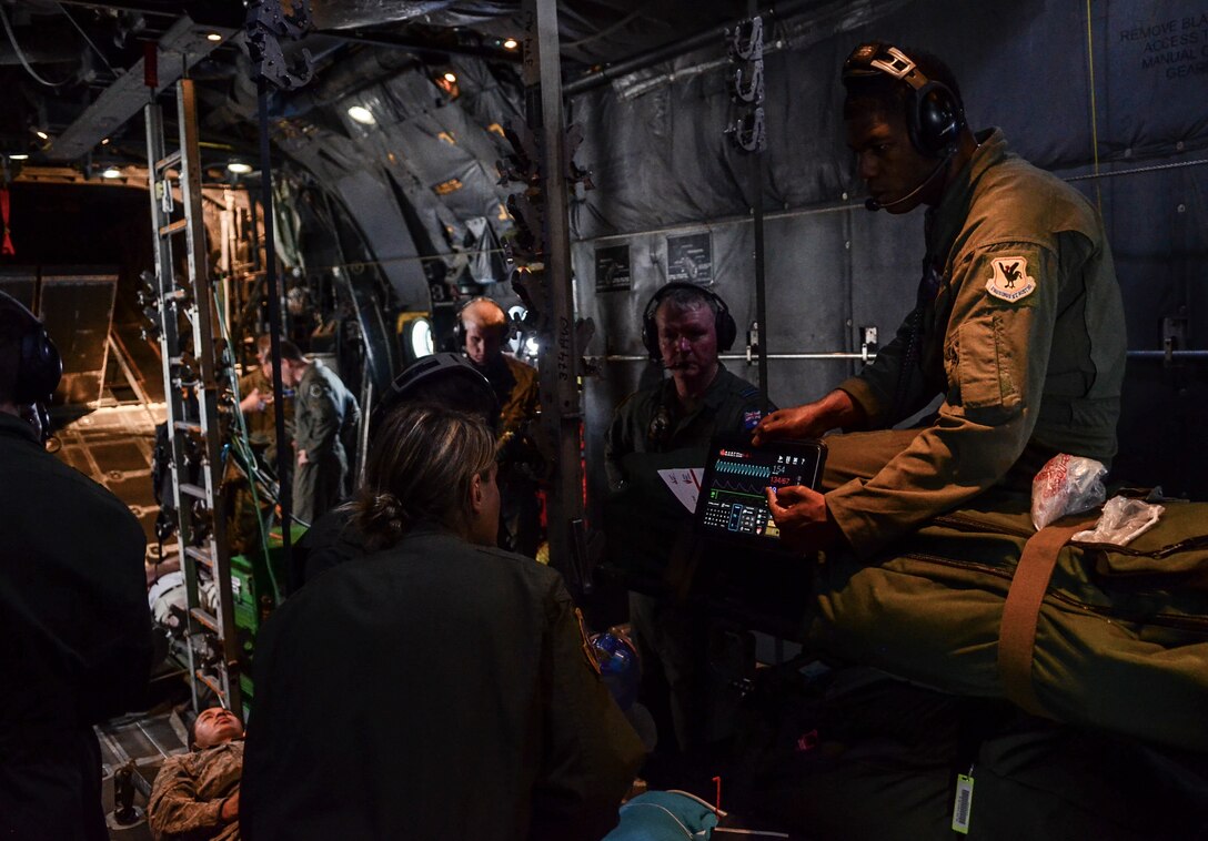 U.S. Air Force Master Sgt. Jaime Tate, 18th Aeromedical Evacuation Squadron Operations Flight chief from Kadena Air Base, Japan, presents a heart monitor simulation to Australian and U.S. AE crewmembers during a patient transport exercise in a C-130 Hercules flying over the Pacific Ocean, Feb. 18, 2014. The patient transport was part of a larger combined humanitarian aid and disaster relief exercise during Cope North 2014. (U.S. Air  Force photo by Senior Airman Marianique Santos/Released)