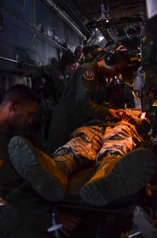 Royal Australian Air Force and U.S. Air Force aeromedical evacuation crewmembers monitor a simulated patient’s vitals during an aeromedical evacuation exercise in a C-130 Hercules flying over the Pacific Ocean, Feb. 18, 2014 as part of Exercise Cope North 2014. Australian and U.S. medical crews worked together as one team to move simulated patients from site on Tinian, Commonwealth of the Northern Mariana Islands, onto a C-130 Hercules and provided medical care for the duration of the flight back to Andersen Air Force Base, Guam. (U.S. Air  Force photo by Senior Airman Marianique Santos/Released)