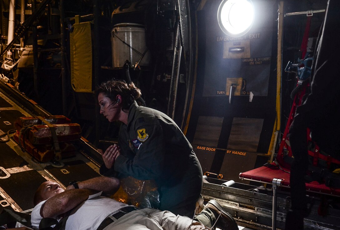 U.S. Air Force Capt. Amy Jacobson, 18th Aeromedical Evacuation Squadron flight nurse from Kadena Air Base, Japan, explains emergency evacuation procedures to a simulated patient during a patient transport exercise in a C-130 Hercules flying over the Pacific Ocean, Feb. 18, 2014. The patient transport was part of a larger combined humanitarian aid and disaster relief exercise for Cope North 2014.  (U.S. Air  Force photo by Senior Airman Marianique Santos/Released)