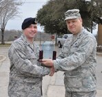 Maj. William Dains II, right, commander of the 433rd Security Forces Squadron, is congratulated by Col. Craig Petersen, 433rd Mission Support Group commander, on March 8 for winning the Air Force Reserve Command’s 2013 Outstanding Security Forces Tenant Unit of the Year award.  