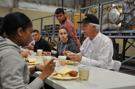 Dave Saylor, manager of Acadiana Cajun Restaurant, talks with members from the 433rd Airlift Wing Developmental Flight during lunch in the Cargo Loading Training Facility. Nearly 20 civilian employers attended  the Alamo Wing Employer Orientation Day on Saturday March 8. Employee Support for the Guard and Reserve sponsored the lunch for visiting employers and their bosses. (U.S. Photo by Tech Sgt. Carlos Trevino)