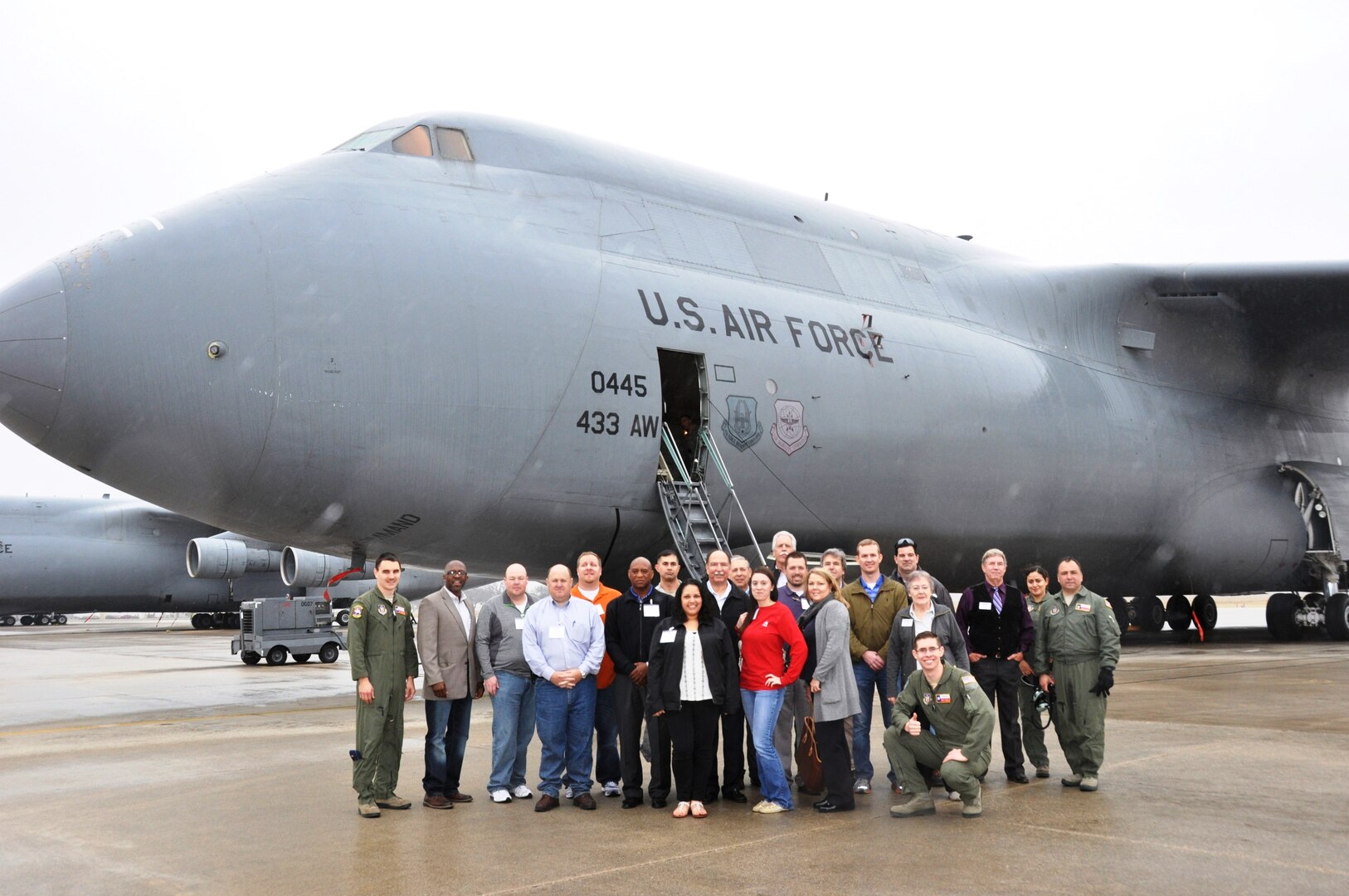 Close to 20 civilian employers pictured here with members from the 433rd Airlift Wing, pose in front of one of the Alamo Wing's C-5A Galaxy aircrafts. Employees visited the 433rd Airlift Wing, March 8, 2014 for Employer Orientation Day.  The employers saw demonstrations from the 433rd Airlift Wing's Maintenance, Aeromedical Evacuation squadrons and the Civil Engineer's Explosive Ordnance Disposal flight.  (U.S. Air Force photo by Tech Sgt. Carlos J. Trevino)