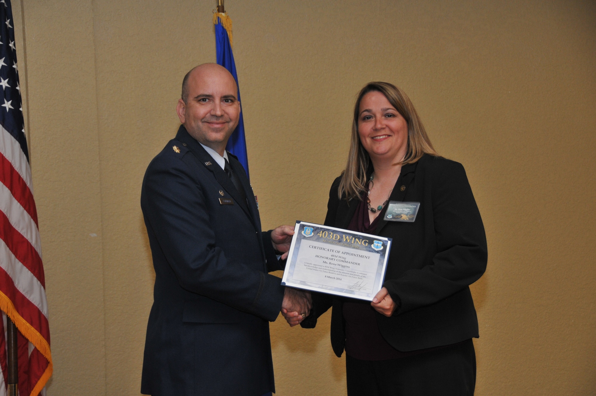 Maj. Paul J. Centinaro, 403rd Aircraft Maintenance Squadron commander, inducts Rena Wiggins, Harrison County Board of Supervisors, into the 403rd Wing Honorary Commander Program March 8, 2014.The program provides Gulf Coast community and corporate leaders the chance to learn more about Air Force personnel, programs and operations, but also affords military commanders and members an opportunity to learn more about the people and the inner workings of their local community. (U.S. Air Force photo/Tech. Sgt. Ryan Labadens)