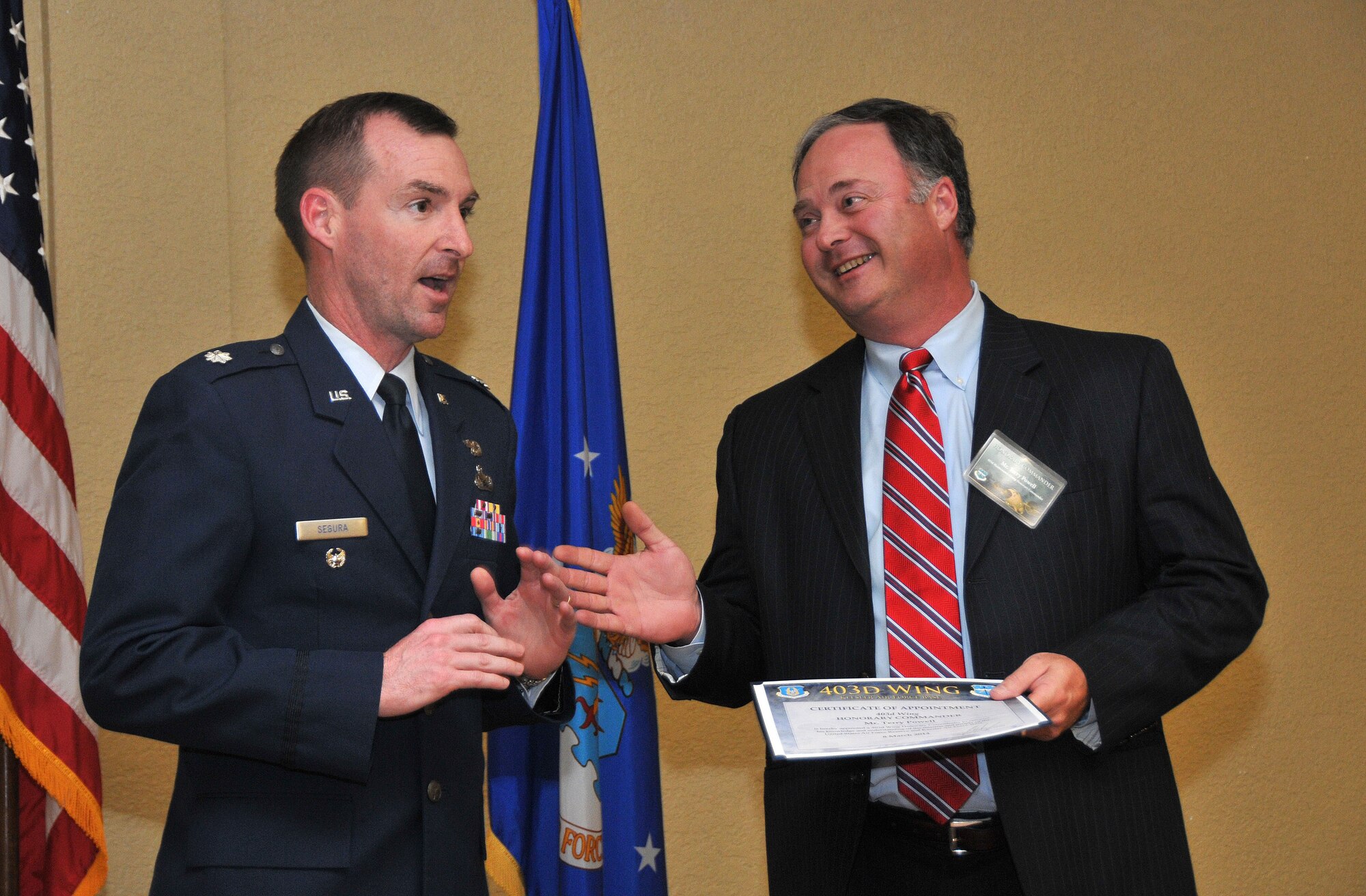 Lt. Col. Edward C. Segura, 403rd Maintenance Group deputy commander, presents a unit coin to Terry Powell, general manager, Edgewater Mall, during the 403rd Wing Honorary Commander Program March 8, 2014. Powell, along with 14 other community and business leaders, was inducted into the program, which provides Gulf Coast community and corporate leaders the chance to learn more about Air Force personnel, programs and operations, but also affords military commanders and members an opportunity to learn more about the people and the inner workings of their local community. (U.S. Air Force photo/Tech. Sgt. Ryan Labadens)