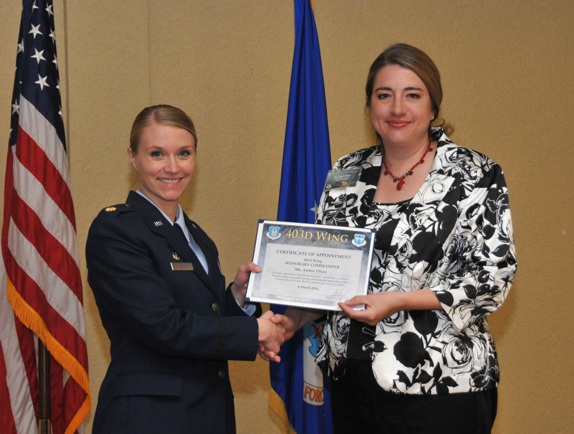 Maj. Salena M. Ingham, 403rd Force Support Squadron commander, inducts Amber Olsen, franchise owner, Nextaff, into the 403rd Wing Honorary Commander Program March 8, 2014.The program provides Gulf Coast community and corporate leaders the chance to learn more about Air Force personnel, programs and operations, but also affords military commanders and members an opportunity to learn more about the people and the inner workings of their local community. (U.S. Air Force photo/Tech. Sgt. Ryan Labadens)