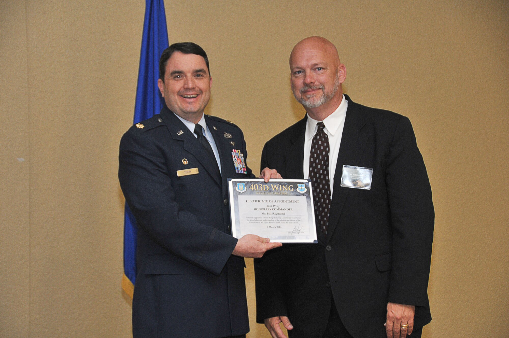 Maj. Joseph B. Terry, 41st Aerial Port Squadron commander, inducts William Raymond, executive planner and historical administrator for the City of Biloxi, into the 403rd Wing Honorary Commander Program March 8, 2014.The program provides Gulf Coast community and corporate leaders the chance to learn more about Air Force personnel, programs and operations, but also affords military commanders and members an opportunity to learn more about the people and the inner workings of their local community. (U.S. Air Force photo/Tech. Sgt. Ryan Labadens)