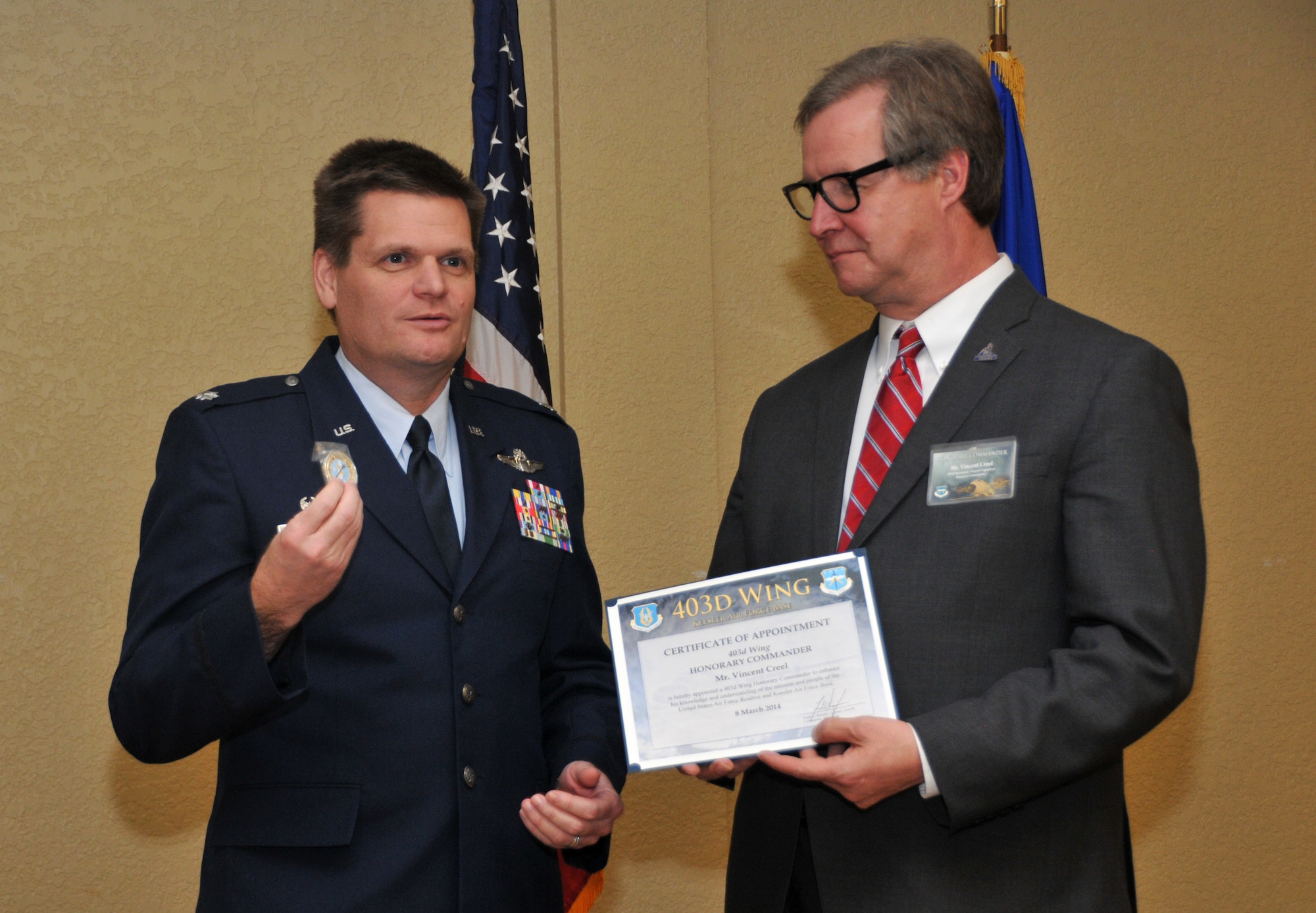 Lt. Col. William E. Bundy, 403d Operations Support Squadron commander, presents a unit coin to newly inducted Honorary Commander Vincent Creel, Public Affairs manager, City of Biloxi. Creel, along with 14 other community and business leaders, was inducted into the 403rd Wing Honorary Commander Program March 8, 2014. The program provides Gulf Coast community and corporate leaders the chance to learn more about Air Force personnel, programs and operations, but also affords military commanders and members an opportunity to learn more about the people and the inner workings of their local community. (U.S. Air Force photo/Tech. Sgt. Ryan Labadens)