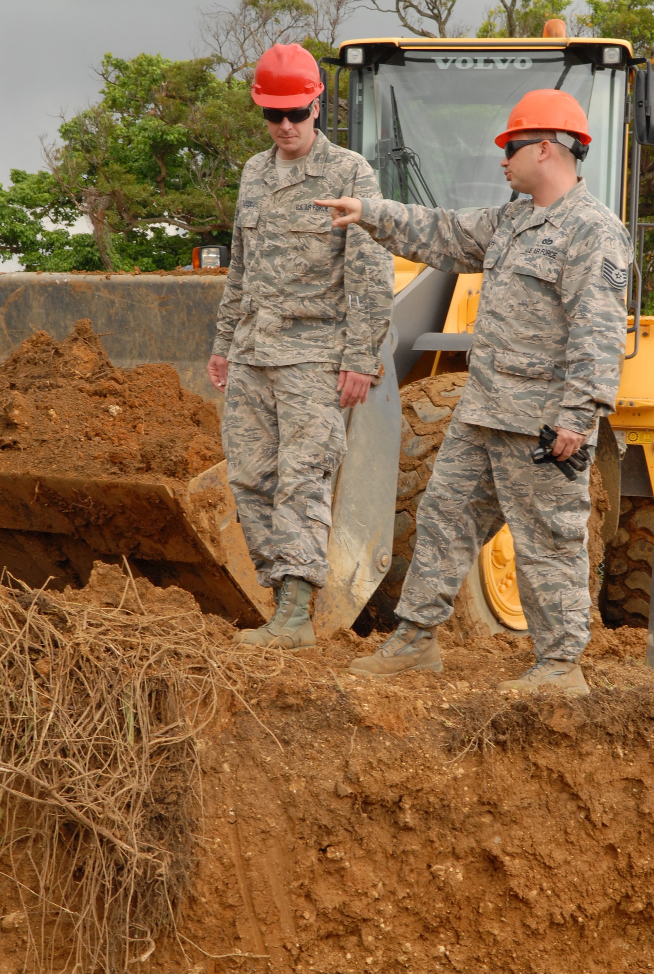 U.S. Air Force Tech. Sgt. William Huff and Staff Sgt. Justin Baker, 18th Civil Engineer Squadron heavy equipment operators, plan their next move to uncover the damaged water main on Kadena Air Base, Japan, March 5, 2014. Sgt. Huff and Sgt. Baker were the heavy equipment operators on site and had to skillfully maneuver the excavator and front end loader around the main pipe line to repair the damaged water main. (U.S. Air Force photo by Airman 1st Class Stephen G. Eigel)