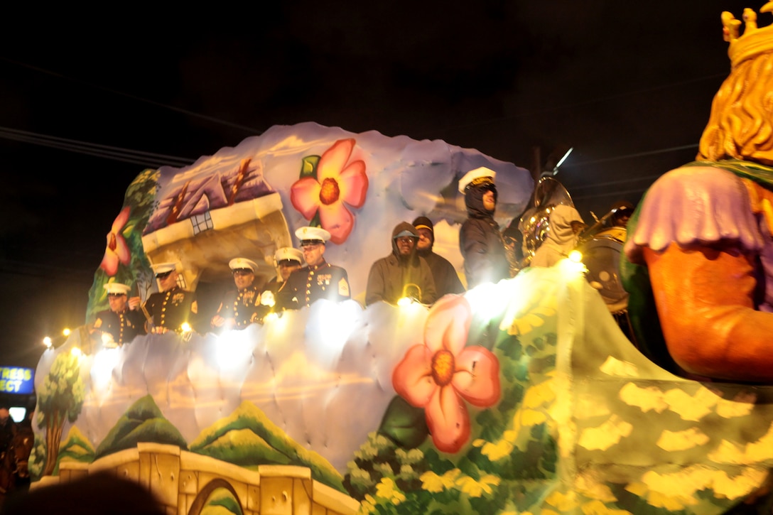 METAIRIE, La. - Marines, sailors and soldiers travel in a parade float throwing beads and other trinkets to the crowd during the Krewe of Zeus parade in Metairie, La., March 3, 2014. Founded in 1957, the Krewe of Zeus is the oldest parading organization in Metairie, a suburb of New Orleans. Zeus abides to a an ancient Greek tradition, beginning their parade with members of the Krewe dressed in period clothing on top of horses and in chariots. The 2nd Marine Aircraft Wing band and color guard from Marine Corps Air Station Cherry Point, N.C., led the parade.  (U.S. Marine Corps Photo by Cpl. J. Gage Karwick/Released)