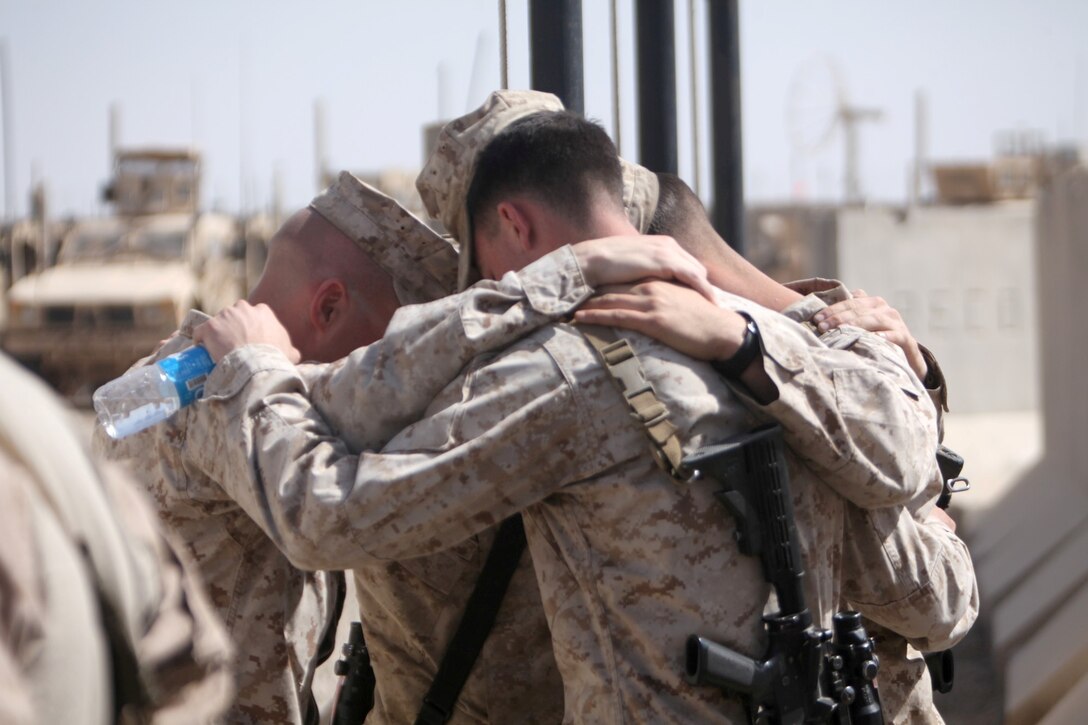 Marines with 1st Battalion, 9th Marine Regiment embrace following the memorial service for their brother-in-arms, Lance Cpl. Caleb L. Erickson, aboard Camp Leatherneck, Afghanistan, March 7. Erickson, of Waseca, Minn., a motor transportation mechanic stationed out of Camp Lejeune, N.C., died while conducting combat operations in Helmand province, Afghanistan, Feb. 28, 2014.