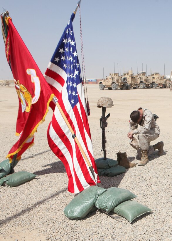 Lance Cpl. Michael Shaffer, a motor transportation operator with 1st Battalion, 9th Marine Regiment, pays his respects to the battlefield cross of his friend, Lance Cpl. Caleb L. Erickson, aboard Camp Leatherneck, Afghanistan, March 7, 2014. Erickson, of Waseca, Minn., a motor transportation mechanic stationed out of Camp Lejeune, N.C., died while conducting combat operations in Helmand province, Afghanistan, Feb. 28, 2014.