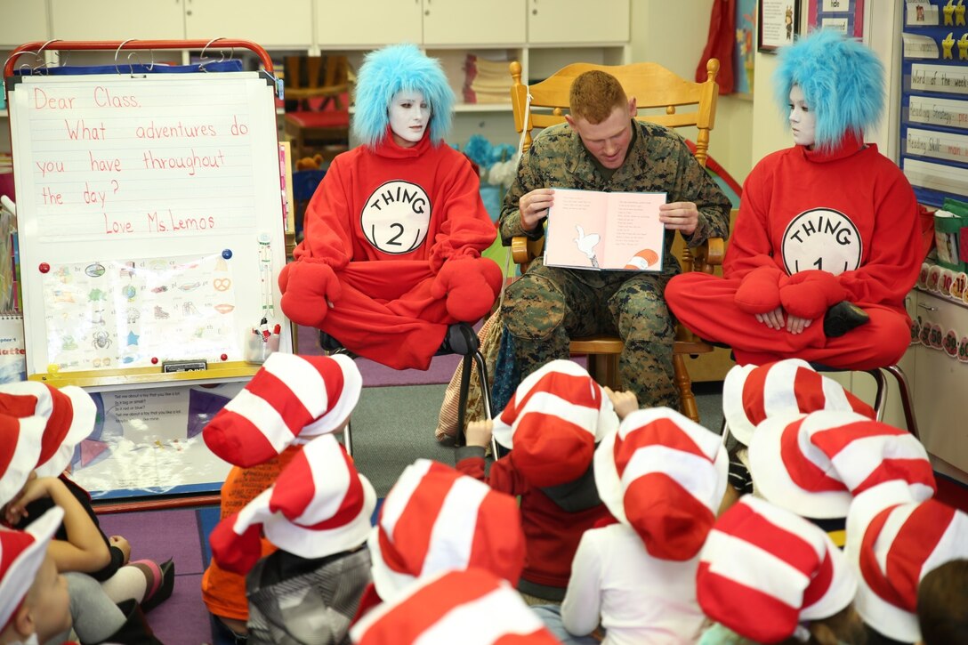 Lance Cpl. Tommy Fears, a flight equipment technician with Marine Aviation Logistics Squadron 12, flanked by Thing 1 and Thing 2, reads to a kindergarten class at Matthew C. Perry Elementary School aboard Marine Corps Air Station Iwakuni, Japan, for Read Across Department of Defense Education Activity Day March 3, 2014. Read Across DoDEA Day is an event which recognizes the birthday of Theodor Seuss Geisel, better known as Dr. Seuss, and focuses on getting children to read.