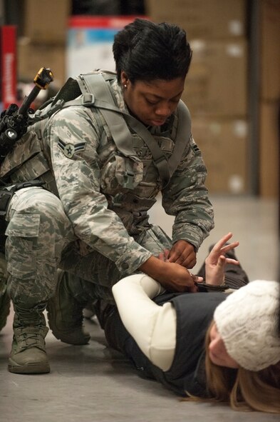 U.S. Air Force Airman 1st Class Najala Logan, 35th Security Forces Squadron member, handcuffs an ?active-shooter? during a Pacific Air Forces High Risk Response course at Misawa Air Base, Japan, March 7, 2014. The course culminates on day five with instructor-led scenarios involving role players and other sensory overload stimuli. (U.S. Air Force photo/Staff Sgt. Nathan Lipscomb)