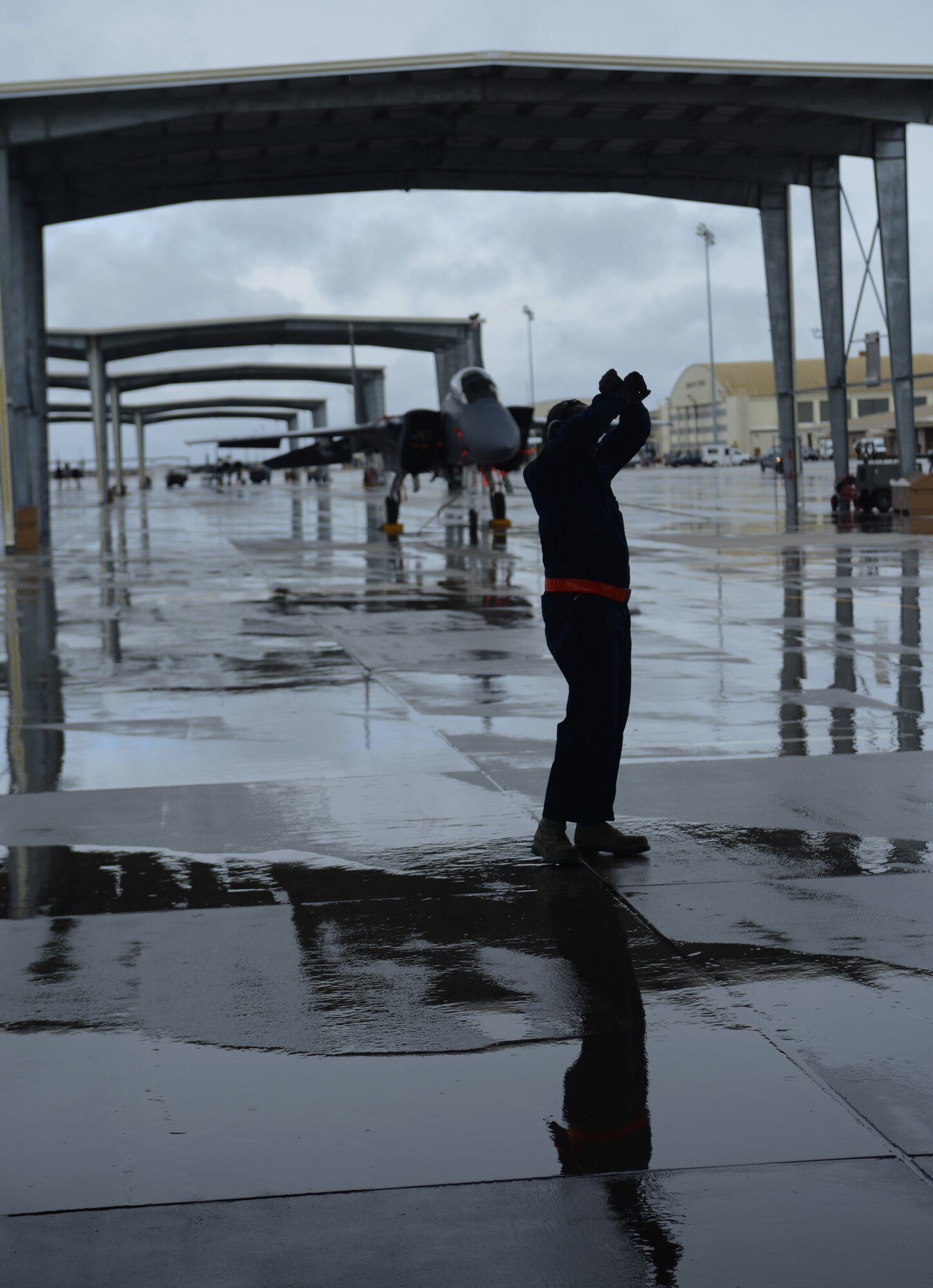 Staff Sgt. Michael Gates, 366th Aircraft Maintenance Squadron crew chief, signals an F-15E Strike Eagle to a halt during a recovery March 10, 2014, at Mountain Home Air Force Base, Idaho. Despite the wet and soggy conditions, Airmen ensured aircraft were able to fly and support the combat exercise Gunighter Flag. Gunfighter Flag will continue thru March 14 and is an excellent opportunity for Gunfighters to receive mission-specific training without having to go on temporary duty orders. (U.S. Air Force photo by Senior Airman Ben Sutton/Released)