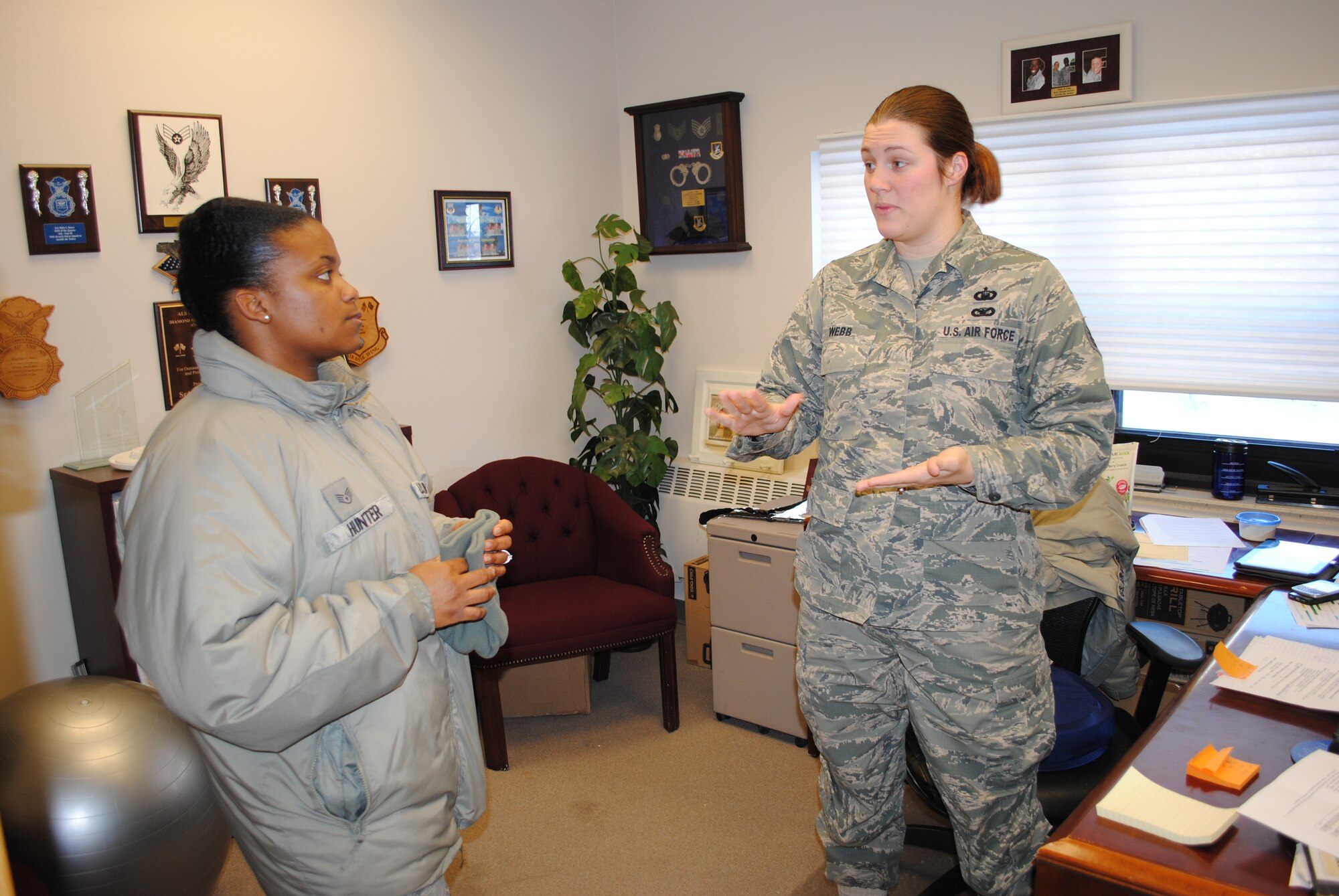 Right: Staff Sgt. Nikki Webb, NCO-in-charge of chapel operations for the 319th Air Base Wing Chapel Office speaks with fellow Staff Sgt. Althea Hunter, 319th ABW Military Equal Opportunity Office, about final preparation for the wing staff agencies' 2013 holiday party, Dec. 18, 2013, at her office at Sven's Den on Grand Forks Air Force Base, N.D. Webb is one of two active-duty chaplain assistants on base. (U.S. Air Force photo/Staff Sgt. Luis Loza Gutierrez) 