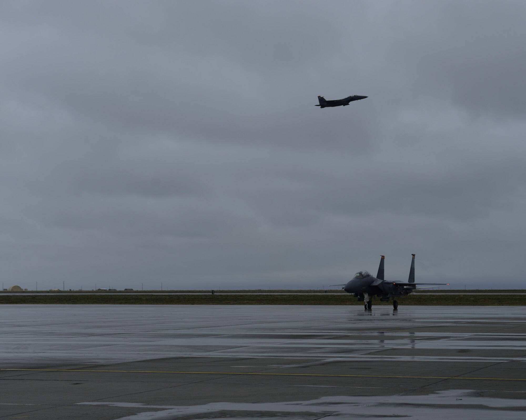 A F-15E Strike Eagle, assigned to the 389th Fighter Squadron, taxis in to park after a mission while another F-15E Strike Eagle, assigned to the 391st FS, takes off behind it March 10, 2014, at Mountain Home Air Force Base, Idaho. Operations out of MHAFB will be increased throughout the week of March 10-14 due to the combat exercise Gunighter Flag. Gunfighter Flag is an excellent opportunity for aircrew members from multiple squadron to train and respond to multiple daily launches. (U.S. Air Force photo by Senior Airman Ben Sutton/Released)

