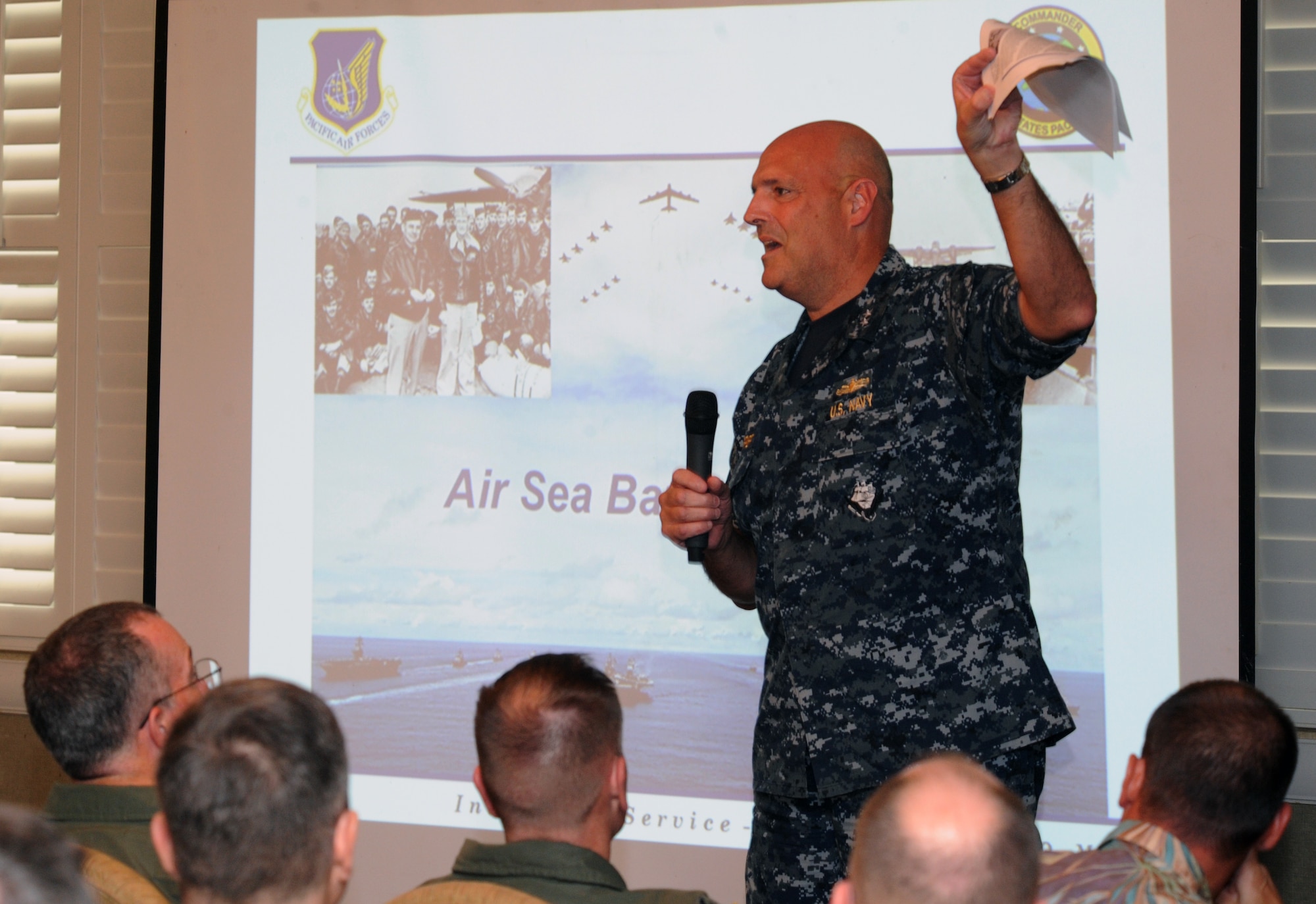 Rear Admiral Robert Girrier, Deputy Commander and Chief of Staff of U.S. Pacific Fleet, speaks while holding a newsletter from the Pentagon’s Air Sea Battle office, during the Pacific Air Forces and U.S. Pacific Fleet’s first Air Sea Battle Forum March 6, 2014, at Joint Base Pearl Harbor-Hickam, Hawaii. The forum served as a venue to promote camaraderie and spark discussions between air and sea components. (U.S. Air Force photo/Master Sgt. Matthew McGovern) 