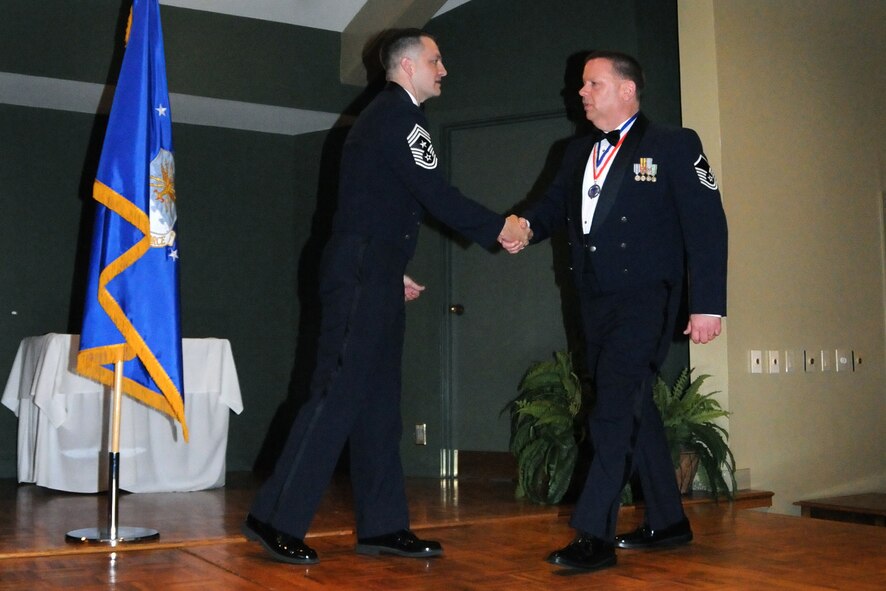 Master Sgt. Andrew Turner, 916th Command Post, is recognized by Command Chief Master Sgt. James Loper for his recent promotion during an NCO induction ceremony held at Walnut Creek Country Club, March 10. The ceremony commemorated the accomplishments of those recently promoted to NCO, Senior NCO, and Chief Master Sgt. ranks. (U.S. Air Force photo by Tech. Sgt. Scotty Sweatt, 916th ARW/PA) 