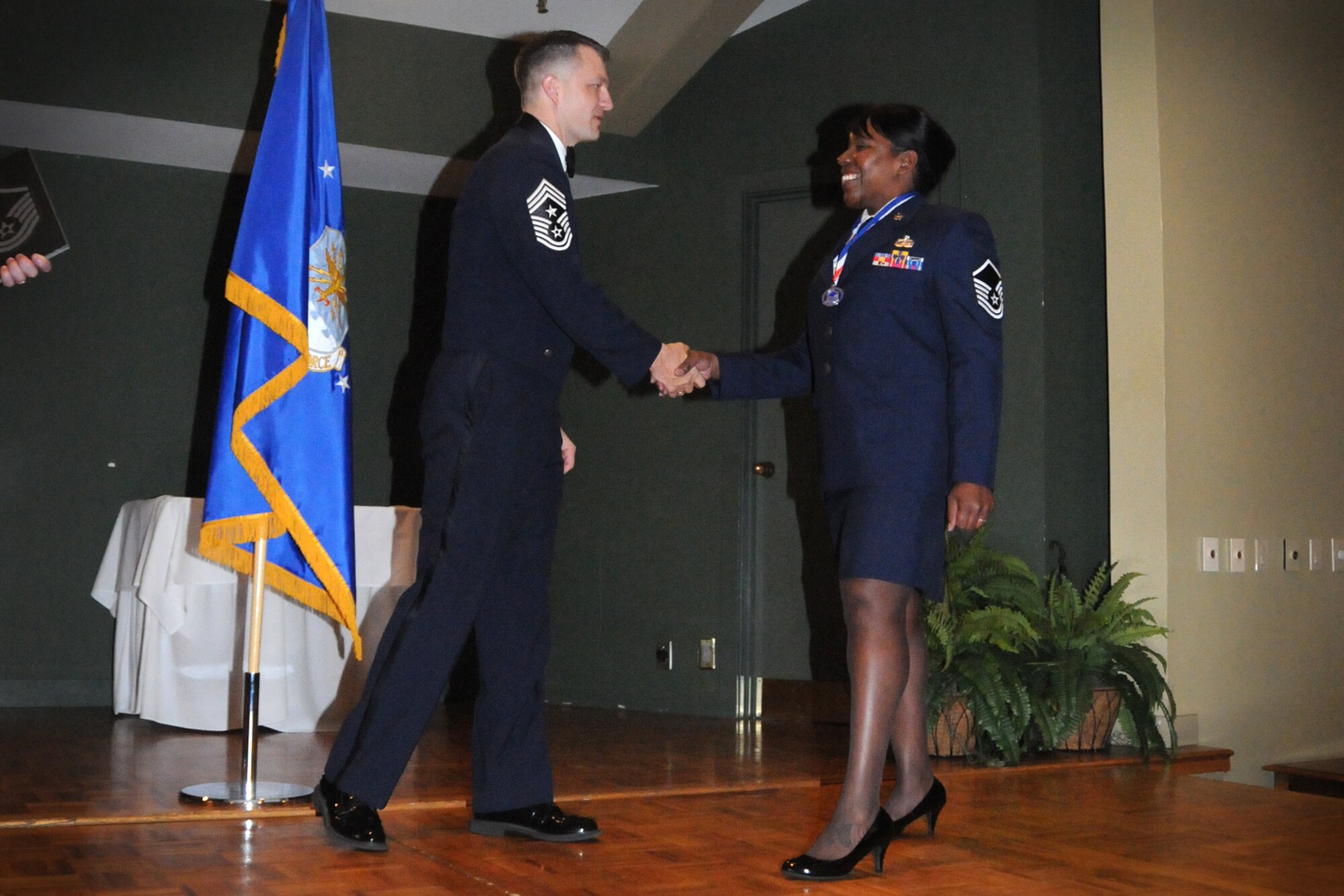 Master Sgt. Diane Speas, 916th Mission Support Group knowledge operations manager is welcomed to the stage by Command Chief Master Sgt. James Loper, during an NCO induction ceremony held at Walnut Creek Country Club, March 10. The ceremony commemorated the accomplishments of those recently promoted to NCO, Senior NCO, and Chief Master Sgt. ranks. (U.S. Air Force photo by Tech. Sgt. Scotty Sweatt, 916th ARW/PA) 