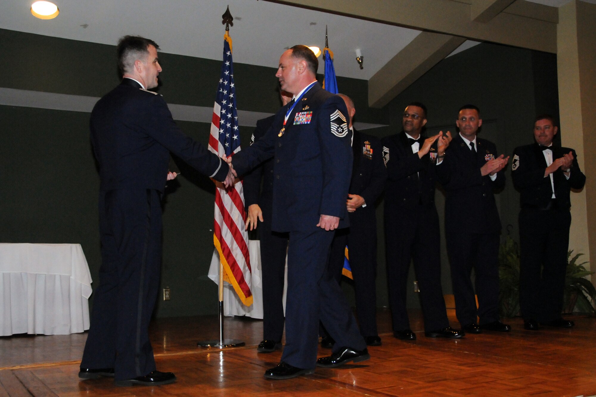 Chief Master Sgt. Gary Smith, 567th Red Horse manager, is recognized by Col. Craig Shenkenberg  for his recent promotion during an NCO induction ceremony held at Walnut Creek Country Club, March 10. Smith and Shenkenberg were joined on stage by all chiefs in attendance. (U.S. Air Force photo by Staff Sgt. Alan Abernethy, 916th ARW/PA) 