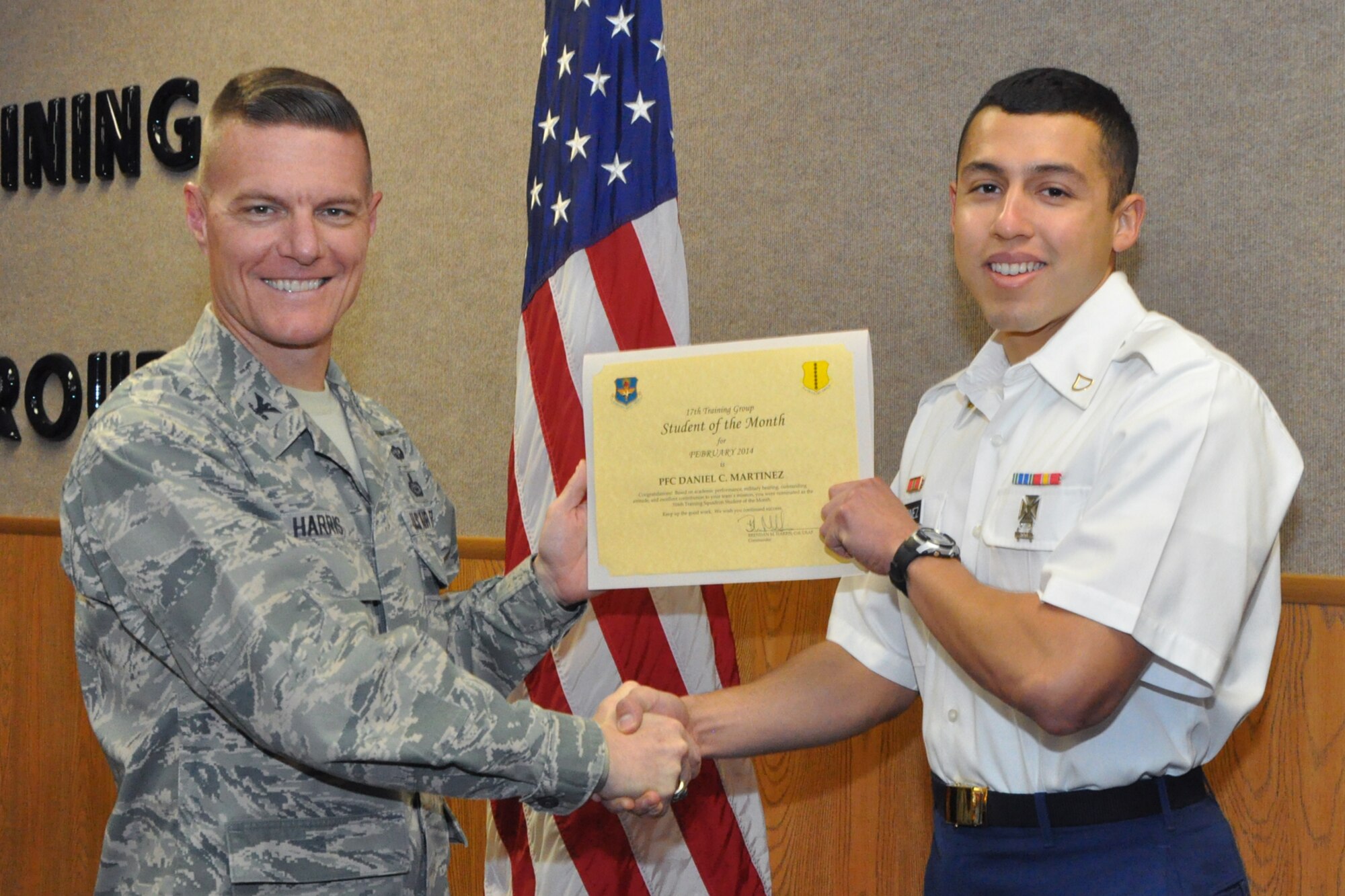 GOODFELLOW AIR FORCE BASE, Texas -- Col. Brendan Harris, 17th Training Group Commander, presents the 316th Training Squadron Enlisted Student of the Month award for February 2014 to Army Pfc. Daniel Martinez, March 7. (U.S. Air Force photo/ Airman 1st Class Breonna Veal)