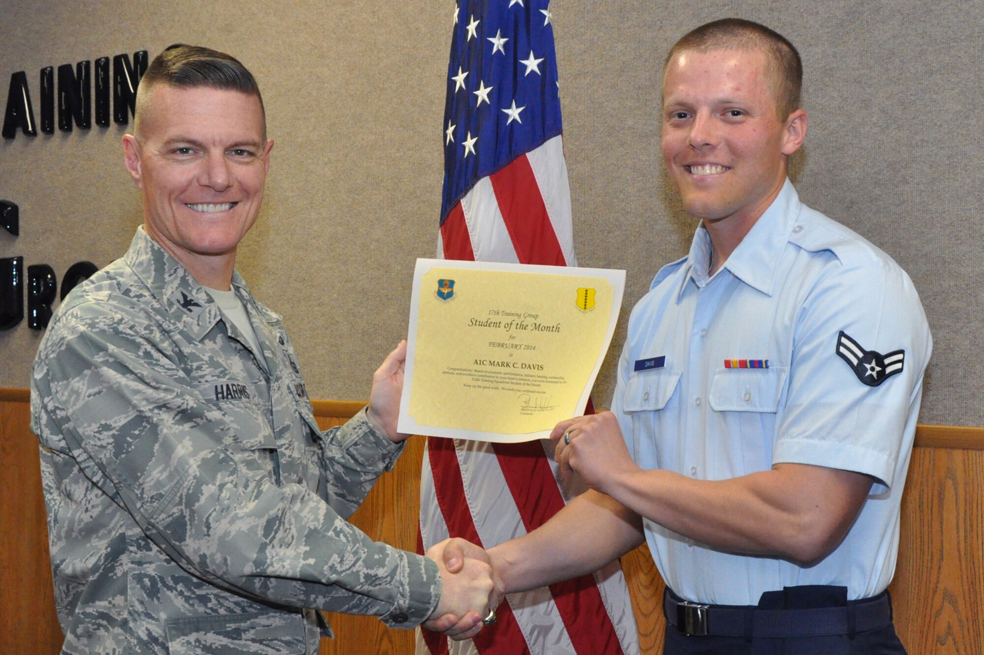 GOODFELLOW AIR FORCE BASE, Texas -- Col. Brendan Harris, 17th Training Group Commander, presents the 312th Training Squadron Enlisted Student of the Month award for February 2014 to Airman 1st Class Mark Davis, March 7. (U.S. Air Force photo/ Airman 1st Class Breonna Veal)