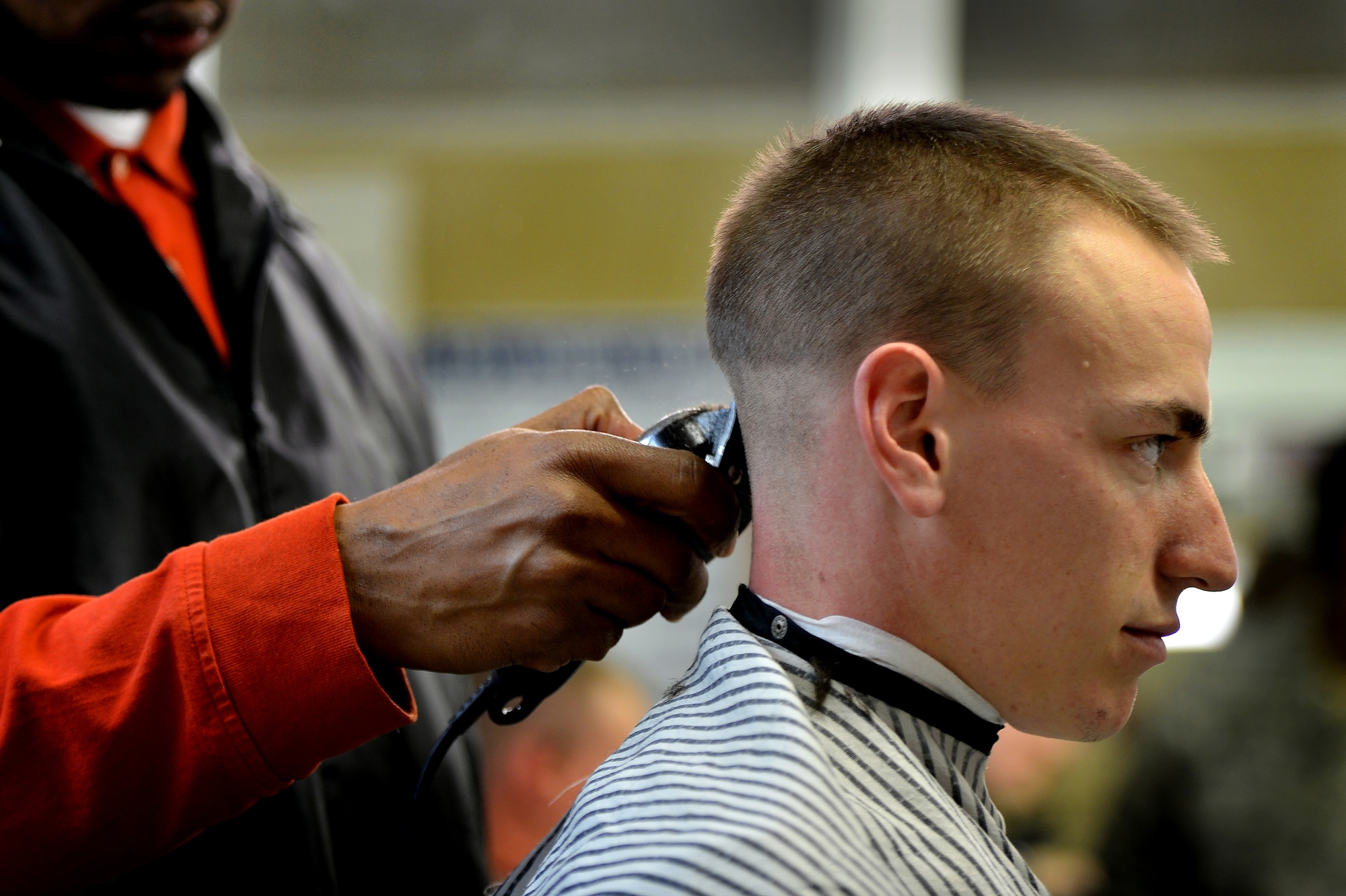 U.S. Air Force Senior Airman Tyler Gurley, 20th Logistics Readiness Squadron has his head shaved at a local barber shop in support of a 20th LRS wingman who was recently diagnosed with cancer, March 5, 2014, Sumter, S.C. Gurley and 13 other Airmen assigned to the 20th LRS pulled together and had their heads shaved to support their wingman who is now undergoing chemotherapy. The team of Airmen expressed a “one team, one fight” mind set and plan to help their wingman as he fights cancer. (U.S. Air Force photo by Staff Sgt. Kenny Holston/Released)