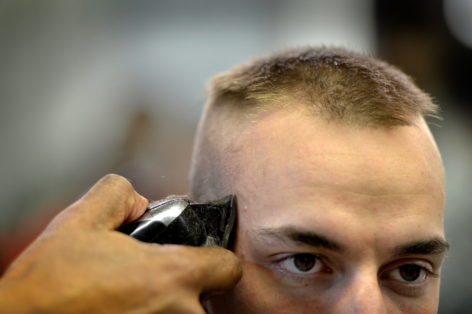 U.S. Air Force Senior Airman Tyler Gurley, 20th Logistics Readiness Squadron has his head shaved at a local barber shop in support of a 20th LRS wingman who was recently diagnosed with cancer, March 5, 2014, Sumter, S.C. Gurley and 12 other Airmen assigned to the 20th LRS pulled together and had their heads shaved to support their wingman who is now undergoing chemotherapy. The team of Airmen expressed a “one team, one fight” mind set and plan to help their wingman as he fights cancer. (U.S. Air Force photo by Staff Sgt. Kenny Holston/Released)