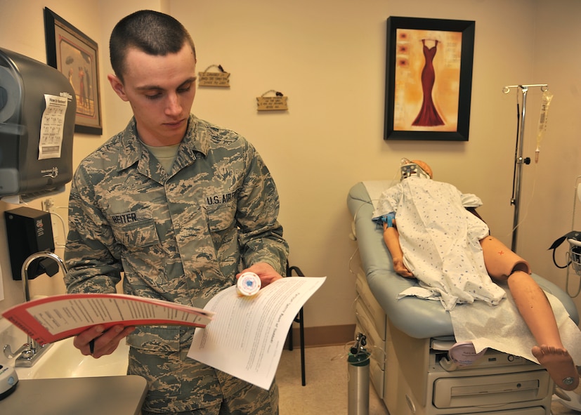 Airman 1st Class Nathaniel Beiter, 319th Medical Support Squadron medical lab technician, confirms the patient information on a prescription pill container during a Patient Safety Room of Horrors challenge on March 6, 2014, at the women’s health clinic on Grand Forks Air Force Base, N.D. Beiter participated in the challenge to find 34 potential or actual patient safety hazards, which is part of a series of activities put on by the 319th MDG in observance of this year’s National Patient Safety Week. (U.S. Air Force photo/Senior Airman Xavier Navarro)