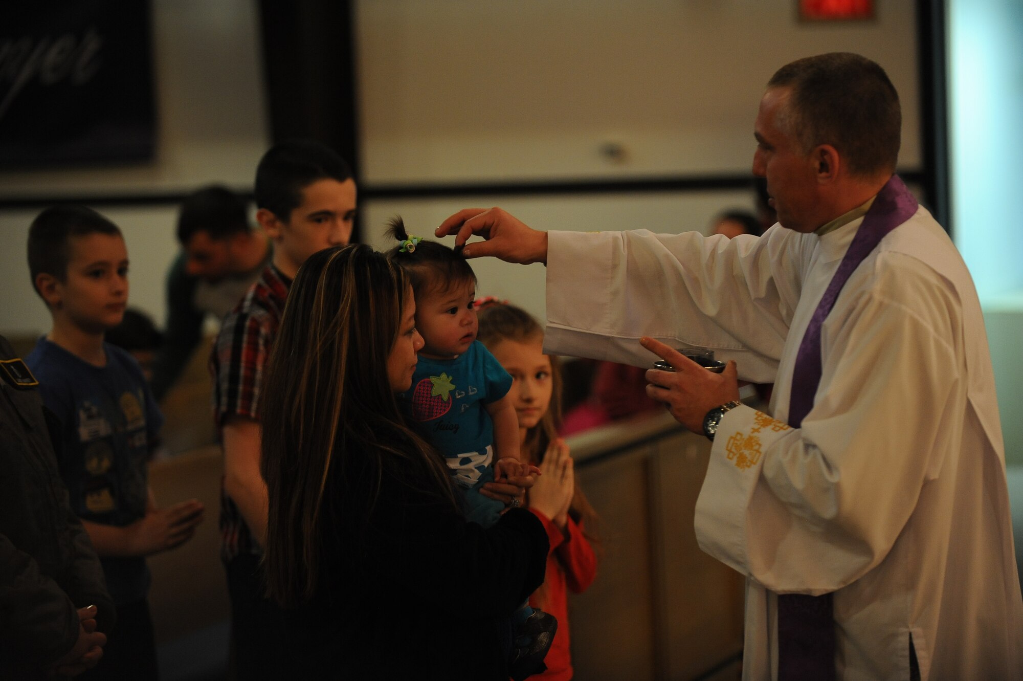 Capt. Piotr Gadja, 5th Bomb Wing Catholic chaplan, led two masses on Ash Wednesday, Mar. 5, 2014 to mark the beginning of Lent. Lent, which is 40 days long, ending on Easter Sunday, is a time for members of the Catholic Church to reset, reevaluate, and make personal sacrifices that may ultimately improve their lifestyle. Using the ashes of burnt palms, Catholics wear the mark of a cross on their foreheads as a symbol of Ash Wednesday. (U.S. Air Force photos/Airman 1st Class Lauren Pitts)