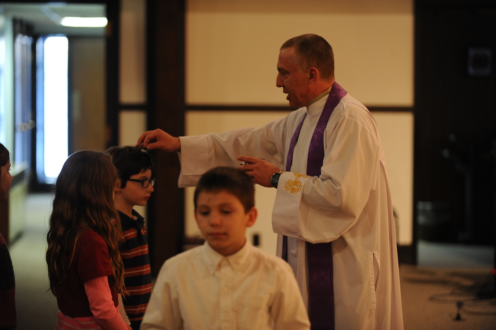 Capt. Piotr Gadja, 5th Bomb Wing Catholic chaplan, led two masses on Ash Wednesday, Mar. 5, 2014 to mark the beginning of Lent. Lent, which is 40 days long, ending on Easter Sunday, is a time for members of the Catholic Church to reset, reevaluate, and make personal sacrifices that may ultimately improve their lifestyle. Using the ashes of burnt palms, Catholics wear the mark of a cross on their foreheads as a symbol of Ash Wednesday. (U.S. Air Force photos/Airman 1st Class Lauren Pitts)