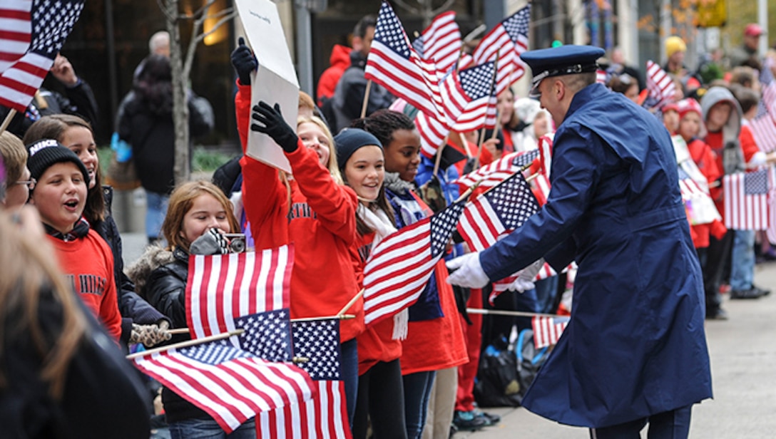 2LT Justin W. Lewis shakes hands with youth enjoying the Pittsburgh, PA Veteran's Day Parade November 11, 2013.