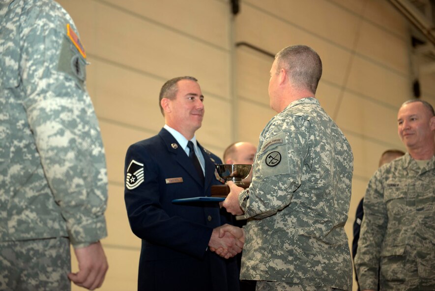 Maj. Gen. James A. Hoyer, Adjutant Generla of West Virginia, presents the James Kemp McLaughlin trophy, awarded to West Virginia's top airman, to Master Sgt. David Martens during an awards ceremony for the Wing's Outstanding Airmen of the Year, March 1. (Air National Guard photo by Tech. Sgt. Michael Dickson/Released) 