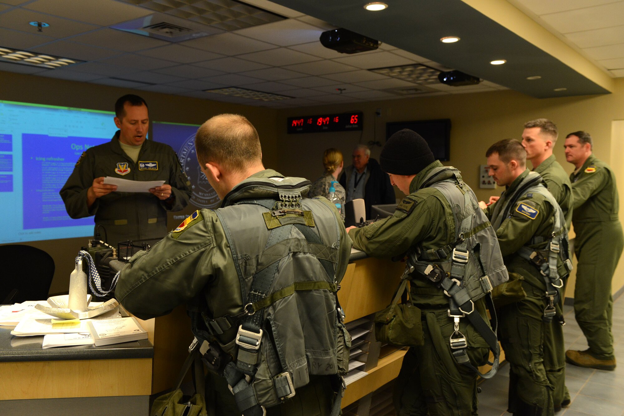 A group of 55th Fighter Squadron pilots listen to a pre-flight weather briefing at Shaw Air Force Base, S.C. March 6, 2014. The pilots were preparing for a training mission during low visibility and rain during severe weather severe weather season which occurs from March through August. (U.S. Air Force photo by Airman 1st Class Jensen Stidham/Released)