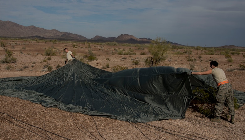 Staff Sgt. Crystal DuBois, right, and Staff Sgt. Alex Palmer, 133rd Logistic Readiness Squadron, Small Air Terminal Section, remove a parachute from the terrain in Yuma, Ariz., Feb. 25, 2014. DuBois and Palmer are two of four assigned to the recovery team. This team is responsible for recovering the training pallets released from the Minnesota Air National Guard C-130 Hercules aircraft. 
(U.S. Air National Guard photo by Tech. Sgt. Amy M. Lovgren/Released)