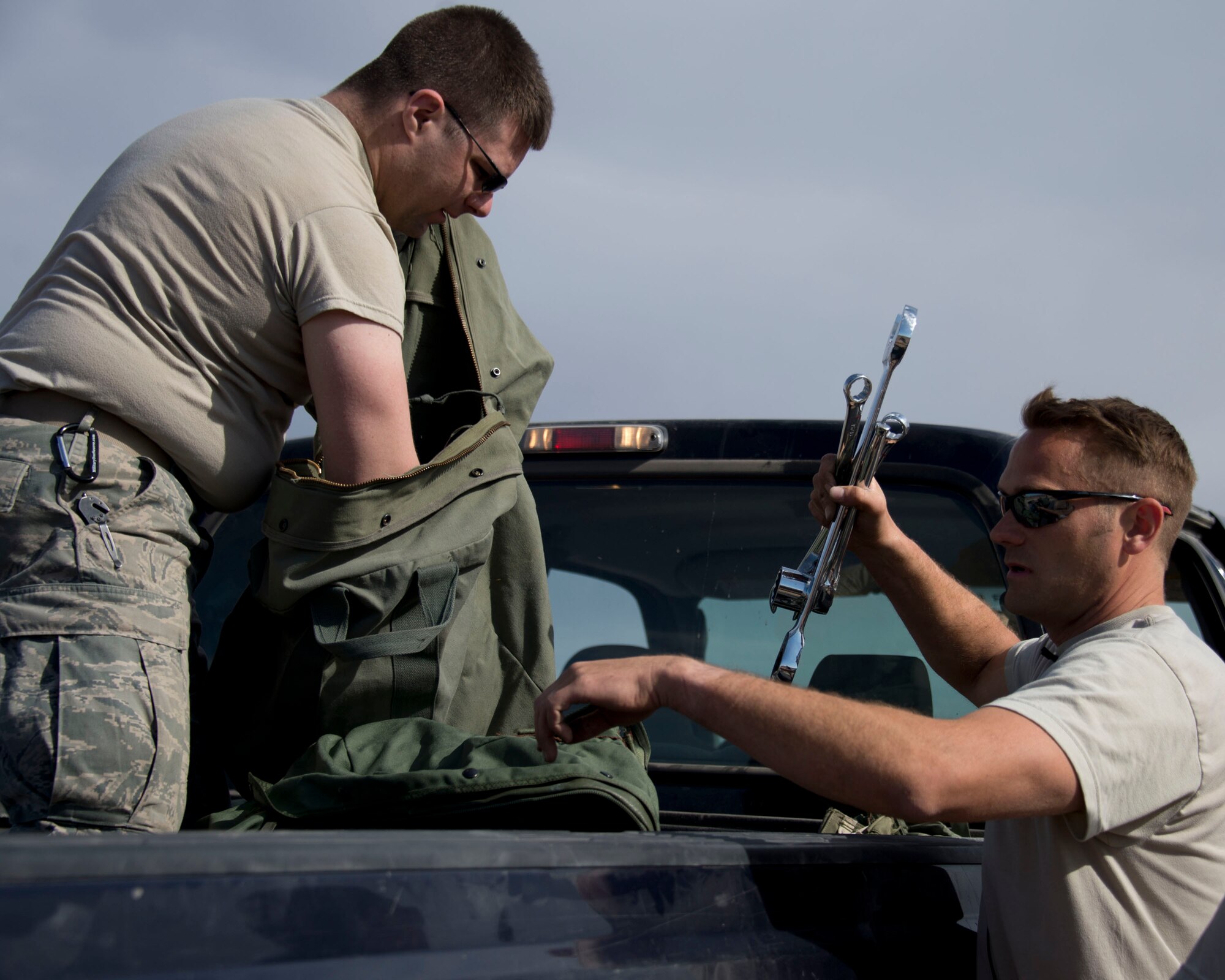 Senior Airman Trevor Norman, left, and Staff Sgt. Casey Jaeger retrieve tools needed to remove the parachute from the heavy load pallet in Yuma, Ariz., Feb. 25, 2014. Norman and Jaeger are two of four assigned to the recovery team. This team is responsible for recovering the training pallets released from the Minnesota Air National Guard C-130 Hercules aircraft. (U.S. Air National Guard photo by Tech. Sgt. Amy M. Lovgren/Released)