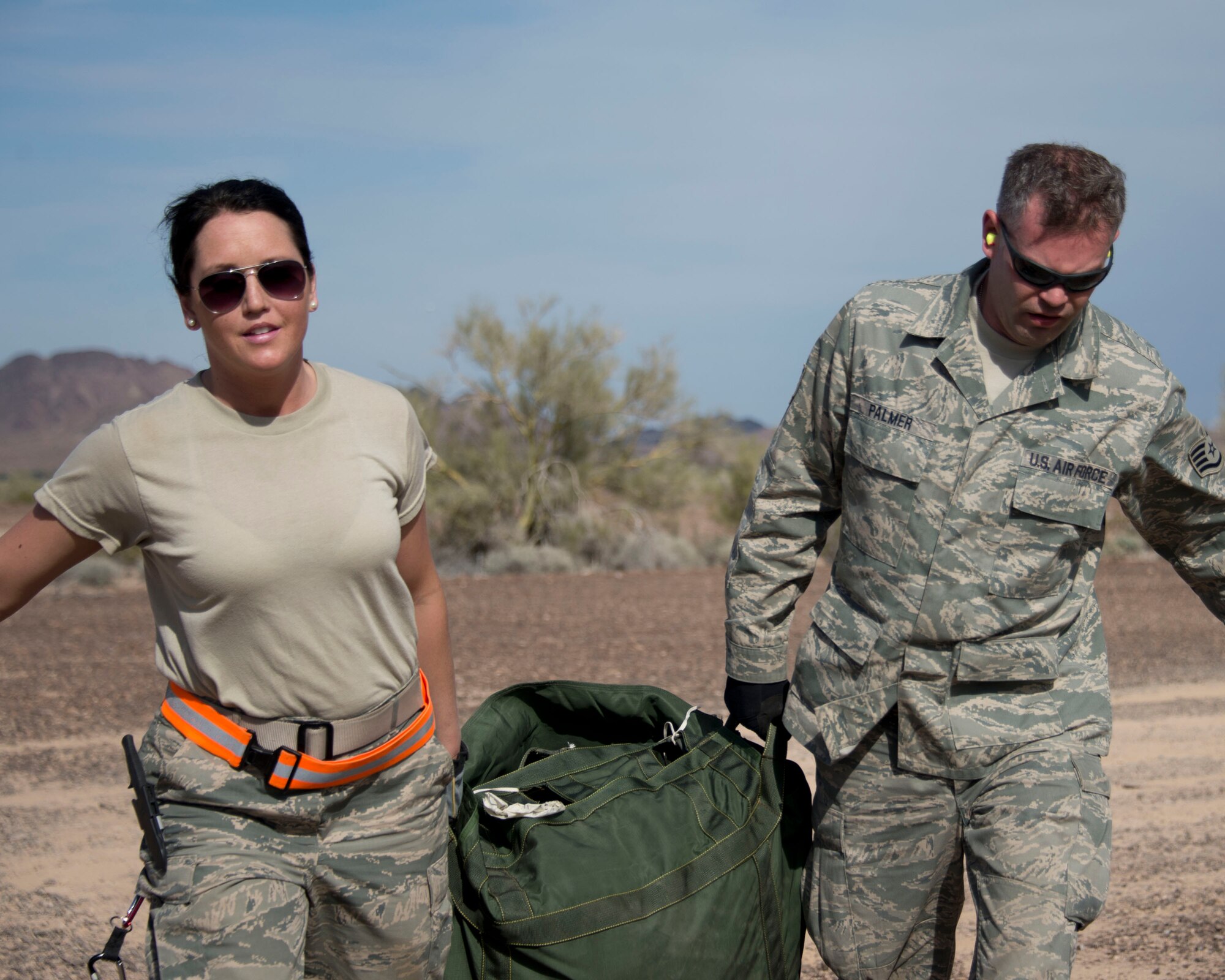 Staff Sgt. Crystal DuBois, left, and Staff Sgt. Alex Palmer drag a packed parachute in Yuma, Ariz., Feb. 25, 2014. DuBois and Palmer are two of four assigned to the recovery team. This team is responsible for recovering the training pallets released from the Minnesota Air National Guard C-130 Hercules aircraft. 
(U.S. Air National Guard photo by Tech. Sgt. Amy M. Lovgren/Released)