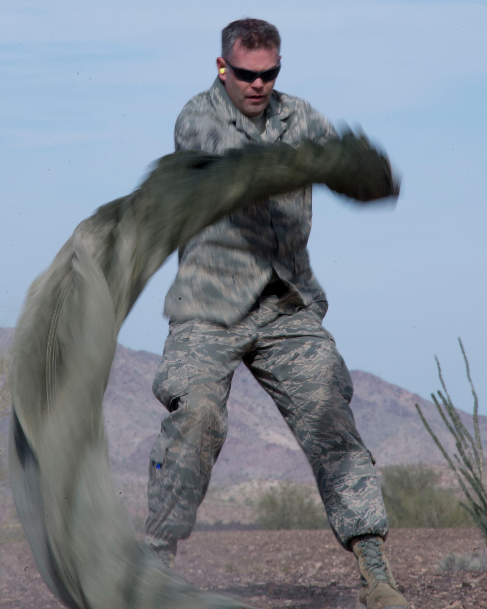 Staff Sgt. Alex Palmer, 133rd Small Air Terminal Section, spins a parachute in Yuma, Ariz., Feb. 25, 2014. Palmer is one of four assigned to the recovery team. This team is responsible for recovering the training pallets released from the Minnesota Air National Guard C-130 Hercules aircraft. (U.S. Air National Guard photo by Tech. Sgt. Amy M. Lovgren/Released)