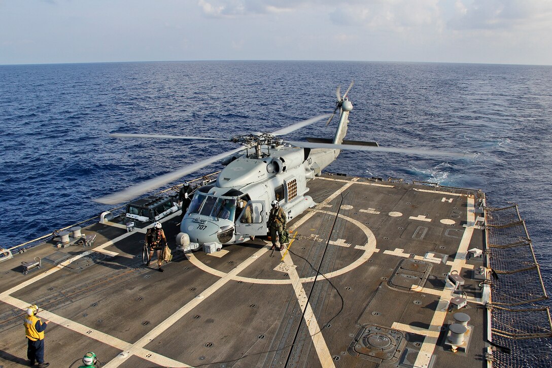 A U.S. Navy MH-60R Seahawk helicopter lands aboard the guided-missile destroyer USS Pinckney during a crew swap before returning to search for the missing Malaysian Airlines flight in the Gulf of Thailand, March 9, 2014. The flight, which dropped off the radar of Subang, Indonesia, traffic controllers early Saturday morning while over the South China Sea, had 227 passengers from 14 nations and 12 crew members. The Seahawk is from the Helicopter Maritime Strike Squadron 78. U.S. Navy photo by Senior Chief Petty Officer Chris D. Boardman