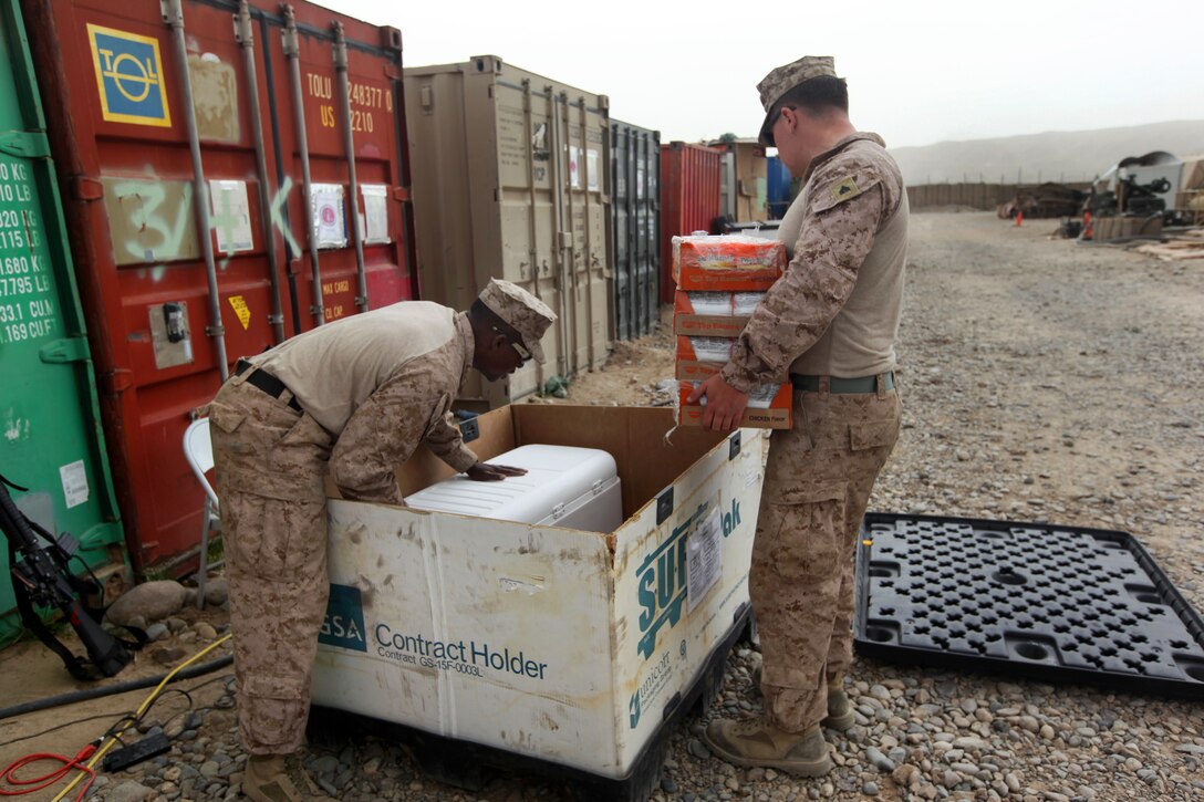 U.S. Marine Corps Sgt. Robert Stone, left, and U.S. Marine Corps Cpl. Shawn Gaffney begin packing unpurchased items into large cardboard boxes on Forward Operating Base Sabit Qadam in Helmand province, Afghanistan, March 8, 2014. Stone, a morale, welfare and recreational specialist, and Gaffney, a disbursing agent, are assigned to the warfighter express services team.