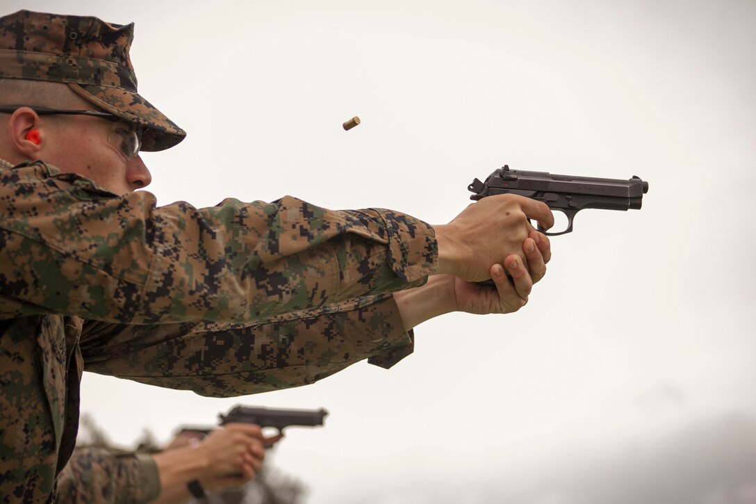 Lance Cpl. Jeffrey A. Sapp, Jr. fires an M9A1 9 mm service pistol Feb. 12 during a qualification course at Camp Hansen. The range hosted a marksmanship coach course Feb. 10 -14, which teaches Marines to coach others on rifle and pistol qualification. Sapp is a student in the course and a small-arms repairer and technician with 3rd Maintenance Battalion, 3rd Marine Logistics Group, III Marine Expeditionary Force.