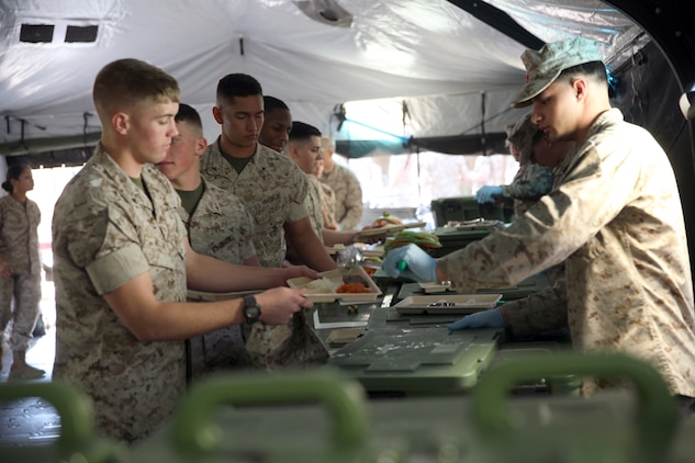 Marines pass through a field kitchen set up by Food Service Company, Combat Logistics Regiment 27, 2nd Marine Logistics Group as part of the W.P.T. Hill Award competition at a site aboard Camp Lejeune, N.C., March 10, 2014. The Marines prepared shepherd’s pie, white beans and chicken chili, and grilled steak for the main entrées. Side choices were rice, cornbread, baked potatoes and biscuits. A separate fruit and salad bar was set up as well.
