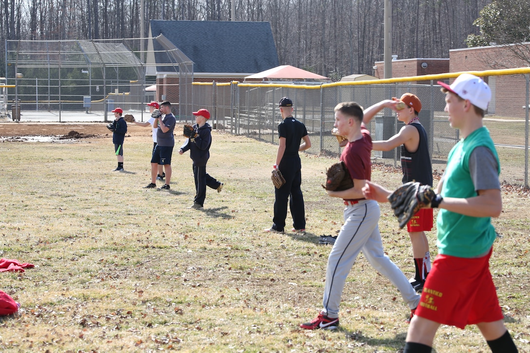 The Quantico Middle/High School Warrior baseball team warms up for their first outdoor practice of the season by playing catch. The team had been confined to the school gymnasium until now due to heavy snow and rain. 