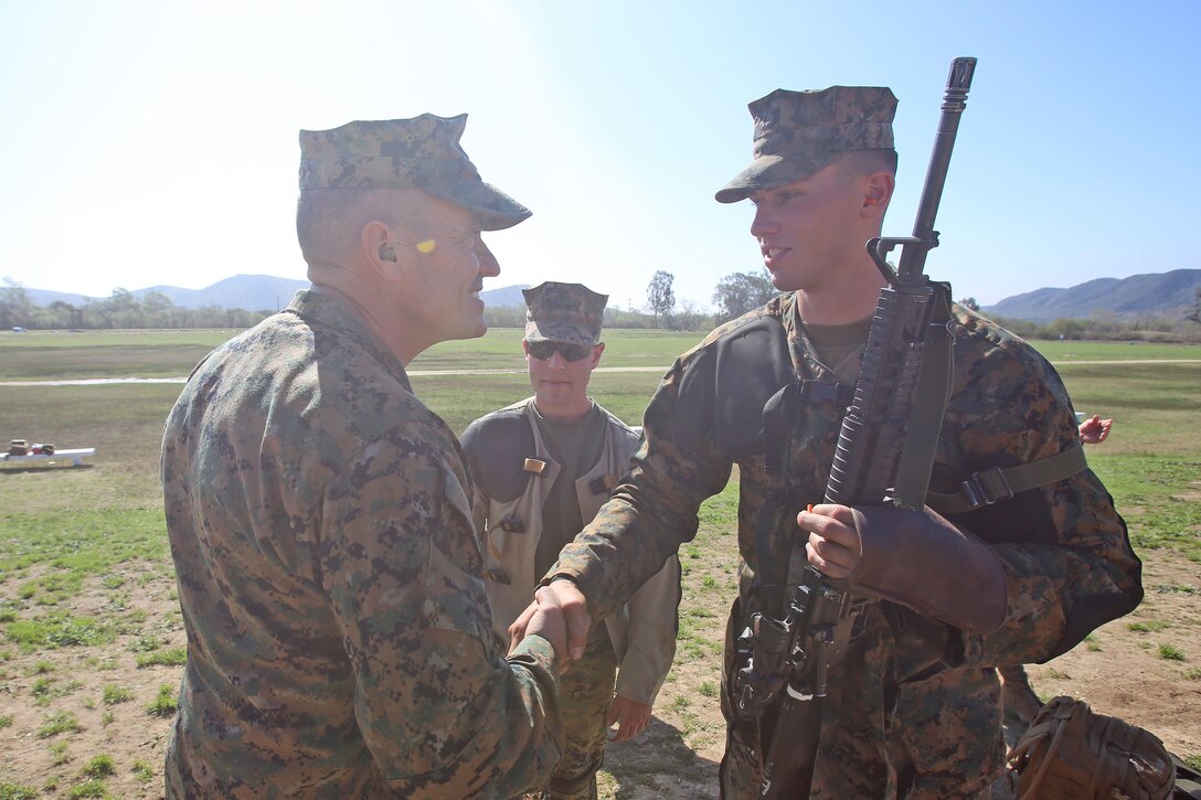 Brig. Gen. Vincent A. Coglianese, commanding general, 1st Marine Logistics Group, greets Pfc. Daniel Pedersen, a field radio operator with Communications Company, Combat Logistics Regiment 17, 1st MLG, during the 2014 Western Division matches aboard Marine Corps Base Camp Pendleton, Calif., March 5, 2014. Marines from CLRs 17, 1, 15 and 7th Engineer Support Battalion, 1st MLG, competed against approximately 200 Marines from throughout the west coast to prove their marksmanship skills with the M16 service rifle, the M4 carbine and the M9 service pistol, Feb 24 – March 7, 2014.