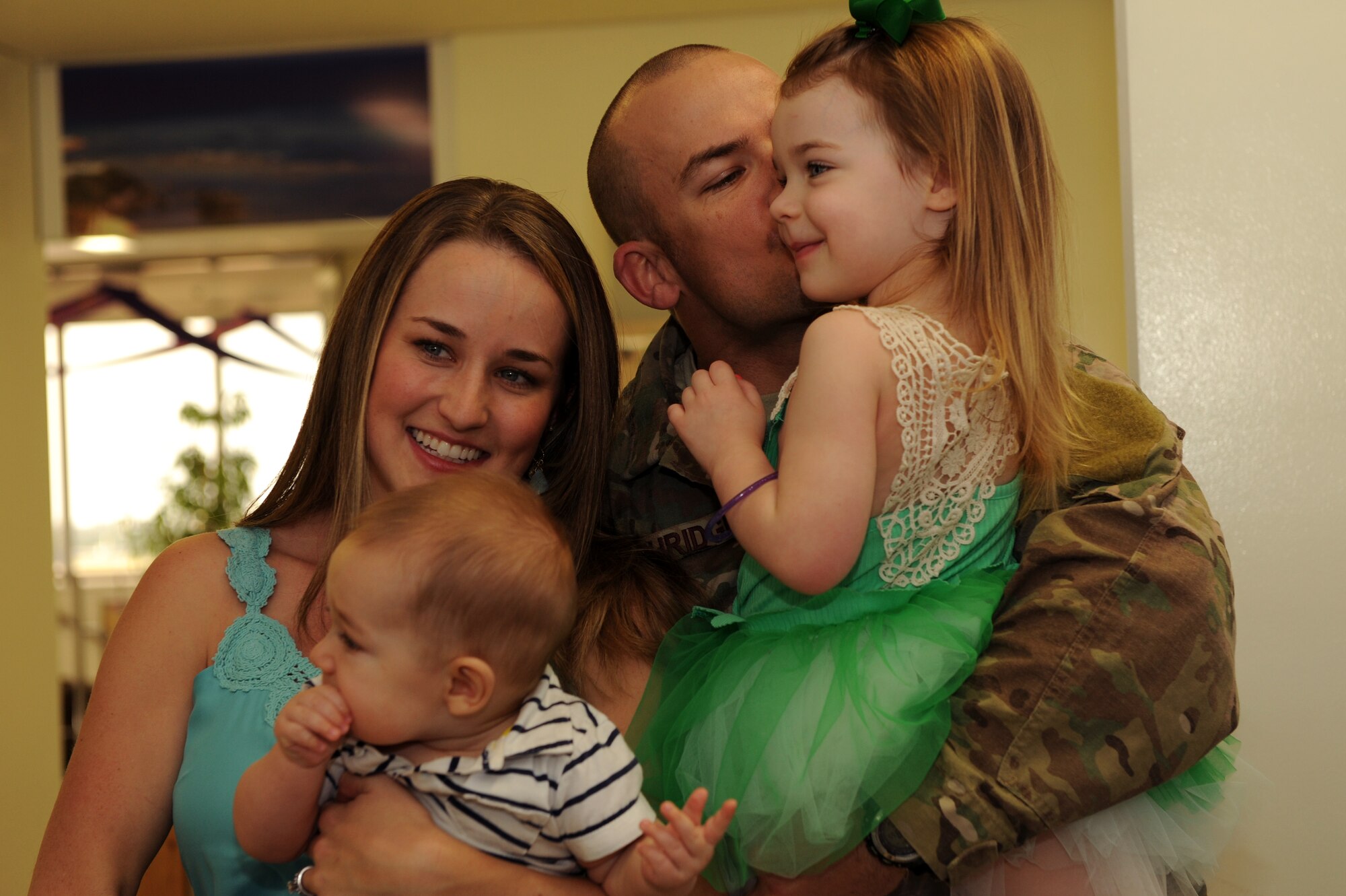 U.S. Air Force Senior Master Sgt. Caleb Ethridge, 31st Rescue Squadron superintendent, kisses his daughter, Daisy, during redeployment at the 733rd Air Mobility Squadron Passenger Terminal on Kadena Air Base, Japan, March 10, 2014. Twenty-seven service members assigned to the 18th Operations Group returned to home station after being deployed and were greeted by family, friends and coworkers upon arrival. (U.S. Air Force photo by Airman 1st Class Hailey R. Staker)